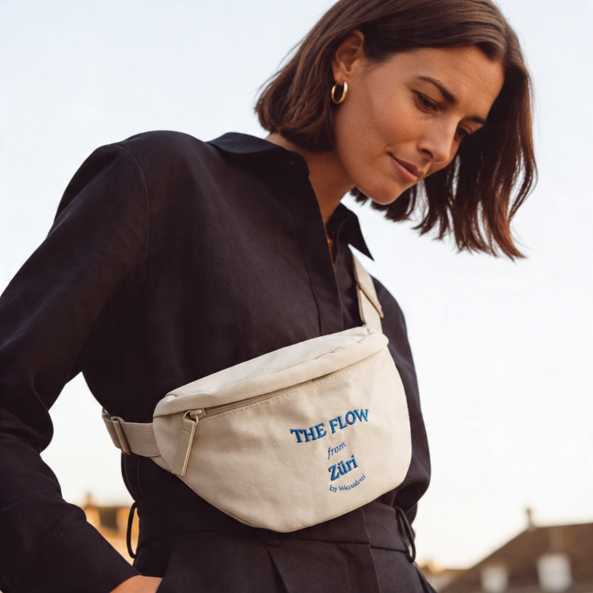 Frau in schwarzem Outfit trägt beige Bauchtasche "The Flow from Züri" von Waswänzi